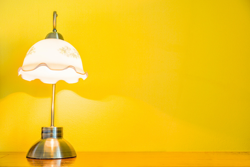 Vintage lamp on wooden table in yellow room. The lighting in romantic bedroom.